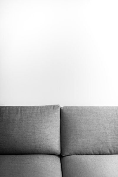 灰色的沙发垫白墙旁边
